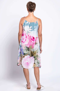 Back view of a woman in a floral knee-length beach cover-up dress with adjustable strap