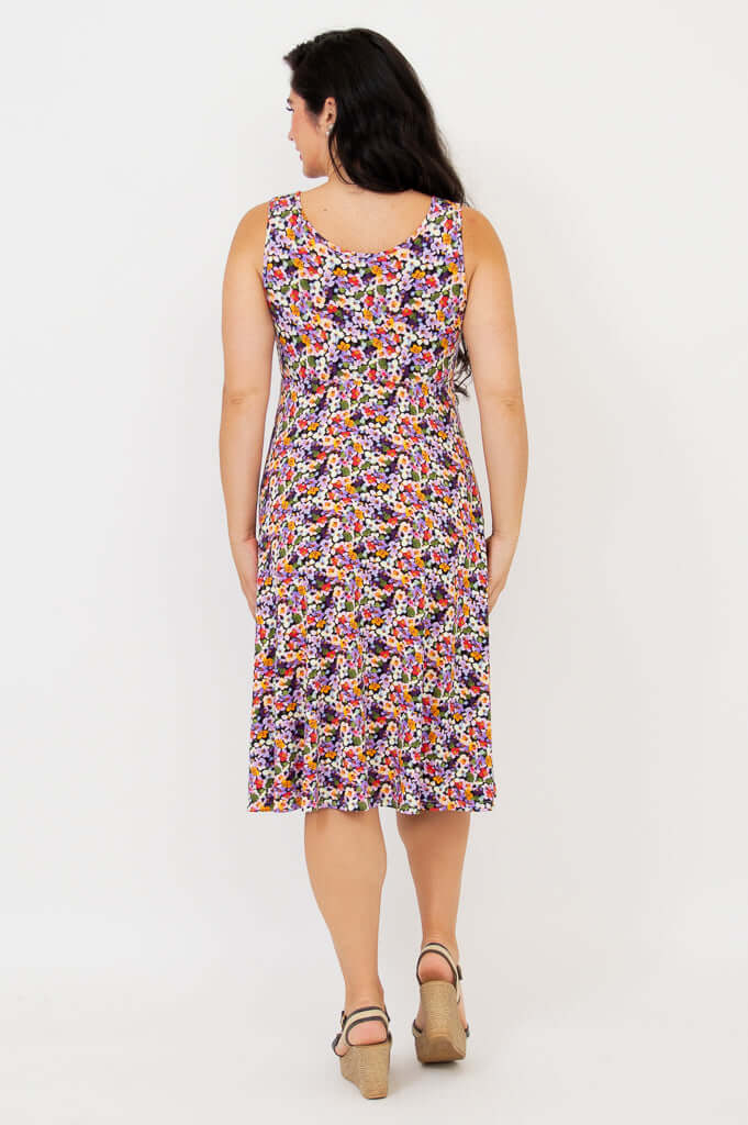 Back view of woman wearing a floral fit and flare dress showing the scoop neckline