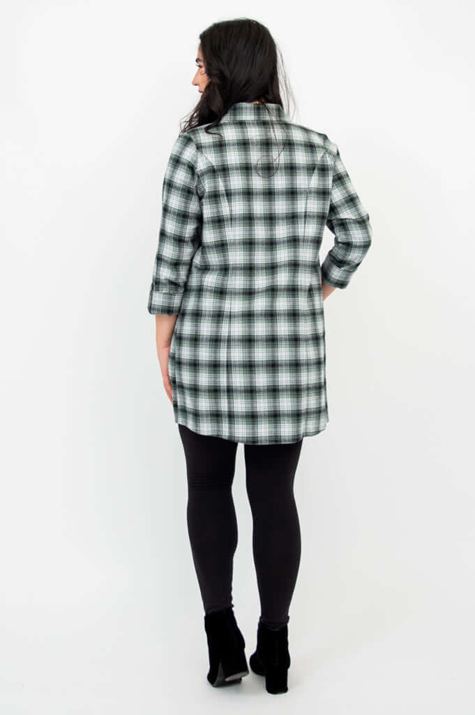 Back view of woman wearing green plaid flannel tunic shirt with 3/4 sleeves