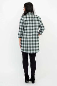 Back view of woman wearing green plaid flannel tunic shirt with 3/4 sleeves