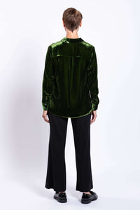 Back view of model wearing green silk velvet blouse showing back pleat detail