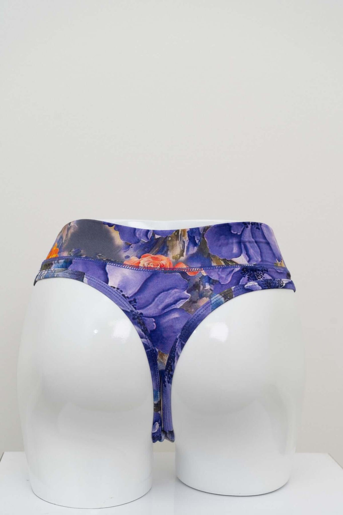 Back view of high rise bamboo thong underwear with purple floral print on mannequin