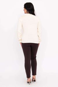 Back view of woman wearing ivory sweater and brown pants