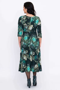 Back view of a woman in a jade green floral midi dress with an A-line skirt
