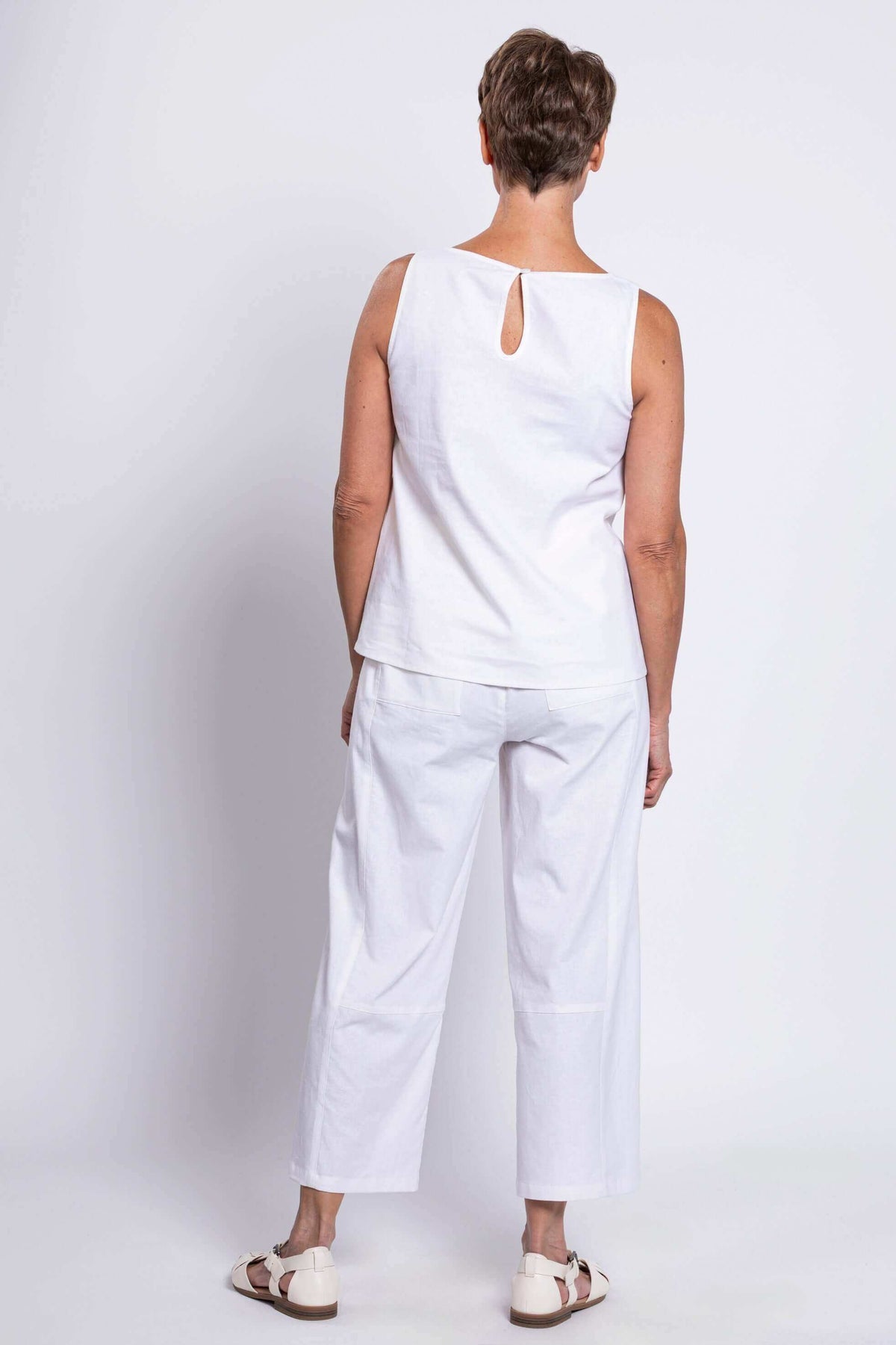 Back view of woman in white linen blend tank showing button closure