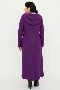 Back view of woman wearing a long purple hooded coat, standing on white background