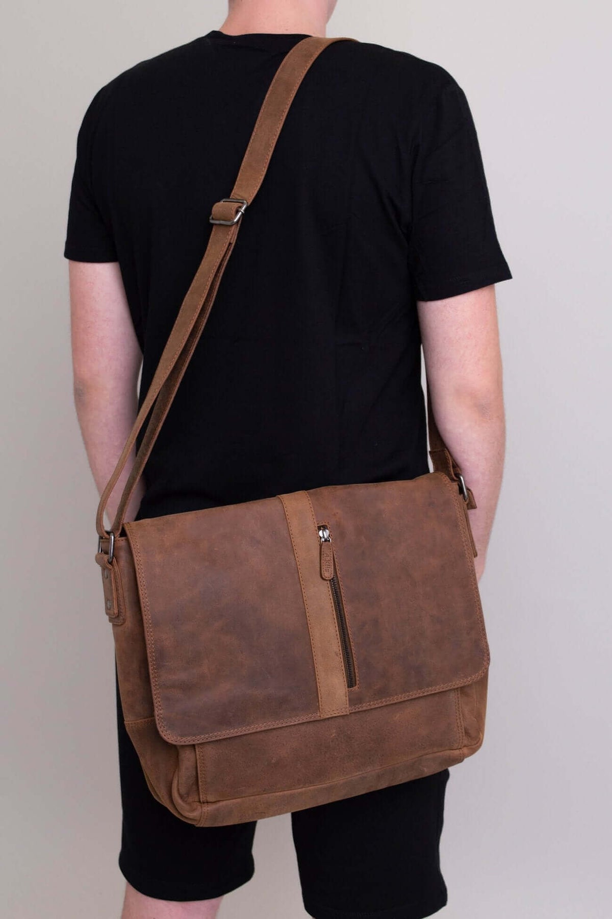 Man from behind showing brown buffalo leather messenger bag with long shoulder strap