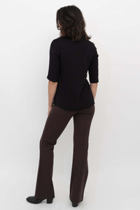 Back view of model wearing Daya Flared Modal Pants in coffee with a black top