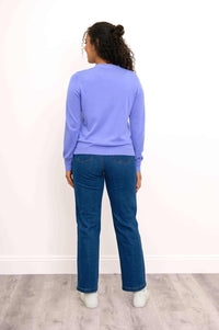 Back view of model wearing a light purple cardigan and blue jeans