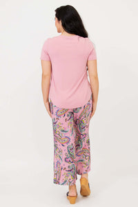 Back view of model wearing light pink Tessa Tee and paisley pants