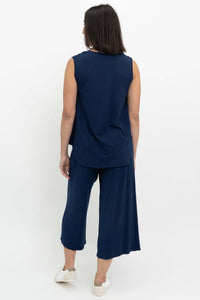 Back view of woman wearing navy blue sleeveless V-neck top and wide-leg pants