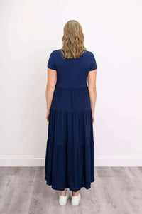 Back view of woman wearing navy blue short sleeve maxi dress with empire waist