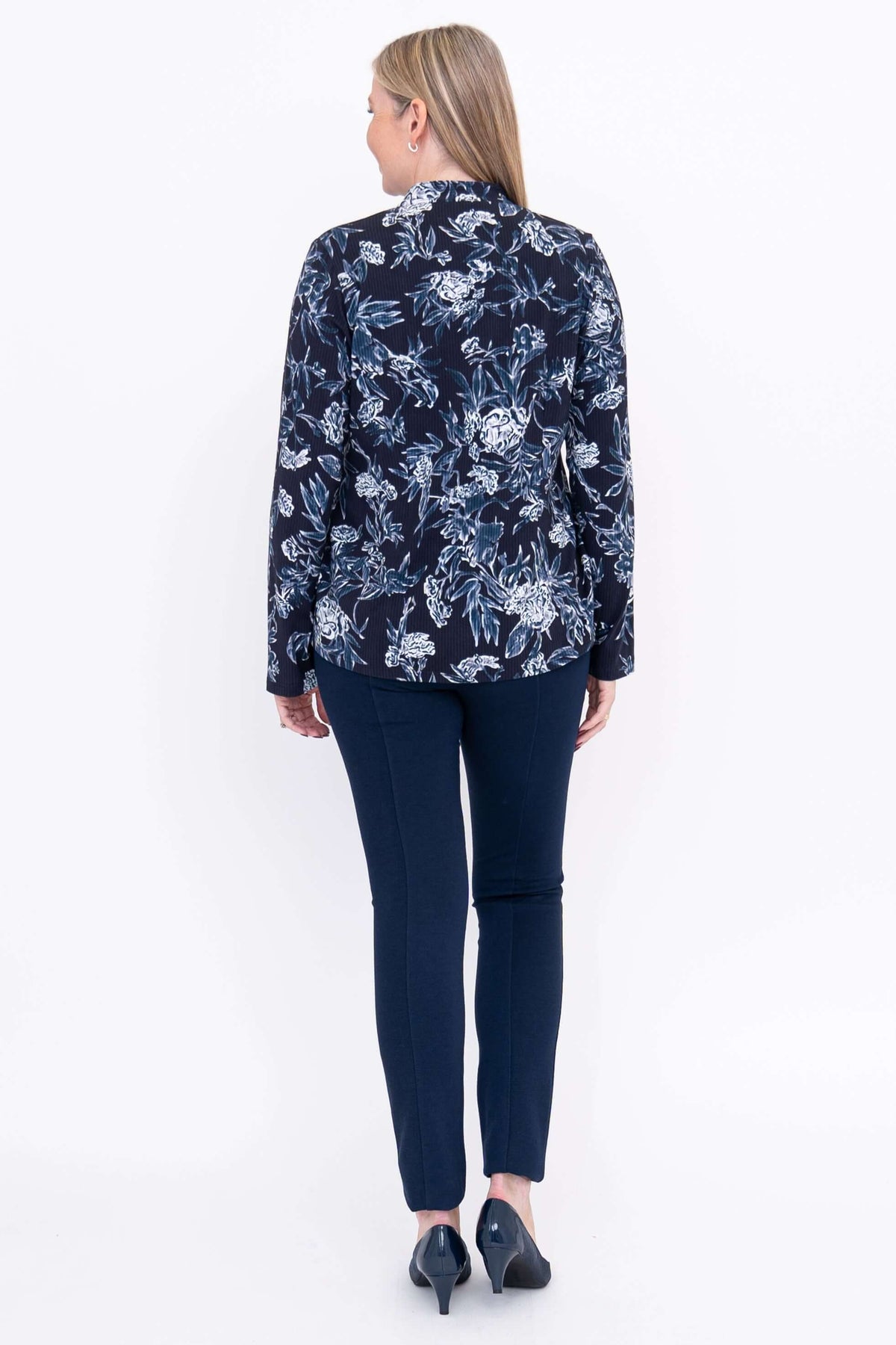 Back view of model wearing navy floral print mandarin collar top with long sleeves