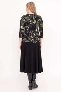 Back view of woman in olive brush print fitted tee and black flared skirt