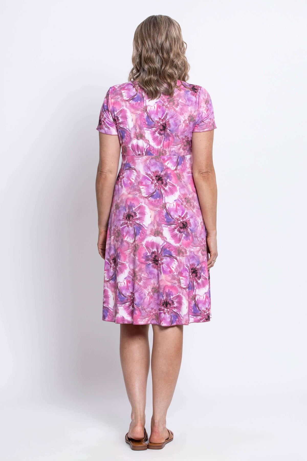Back view of woman in a pink and purple floral bamboo knee-length dress