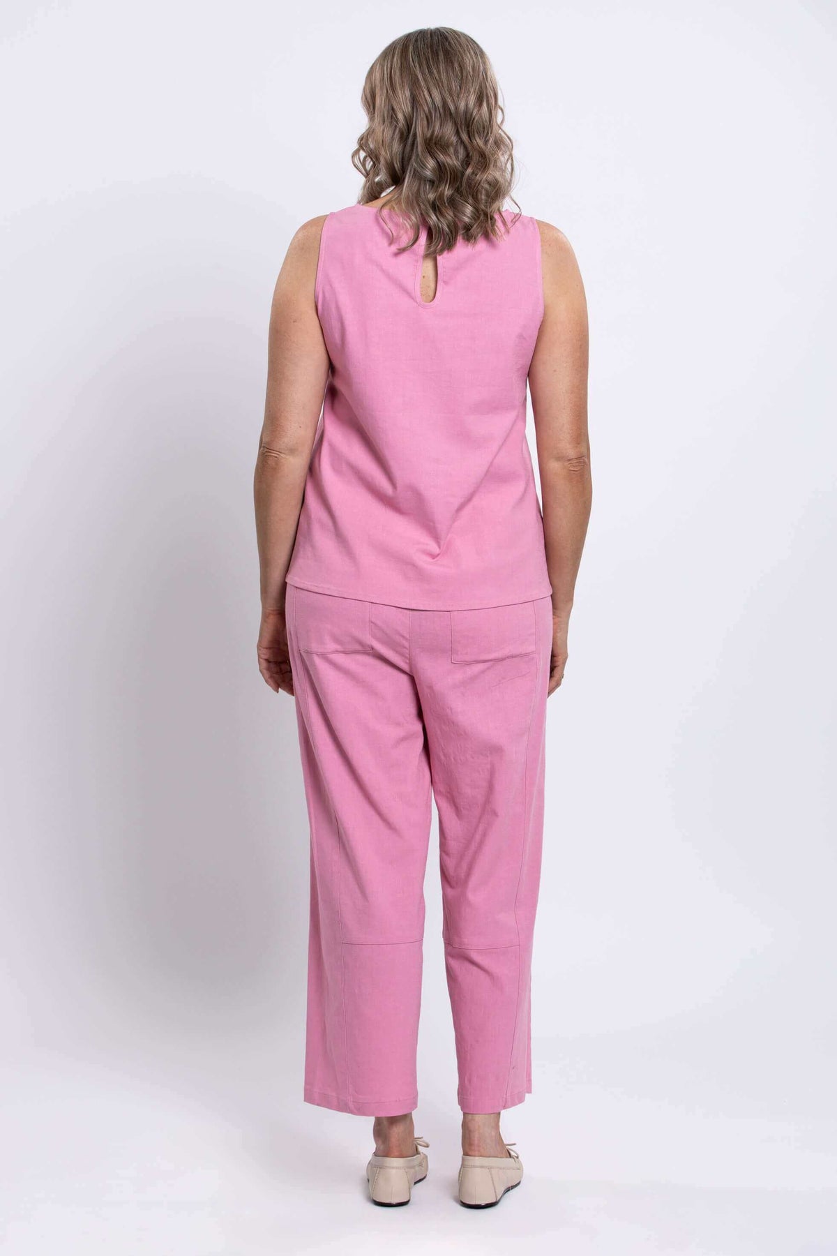 Model showing back view of pink Boardwalk Pants and top, wide leg cut visible