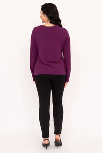 Back view of woman in a purple long sleeve top and black pants