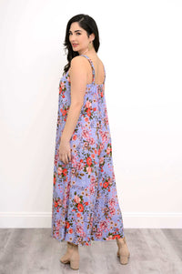 Back view of a woman wearing a purple floral jumpsuit with red and pink flowers