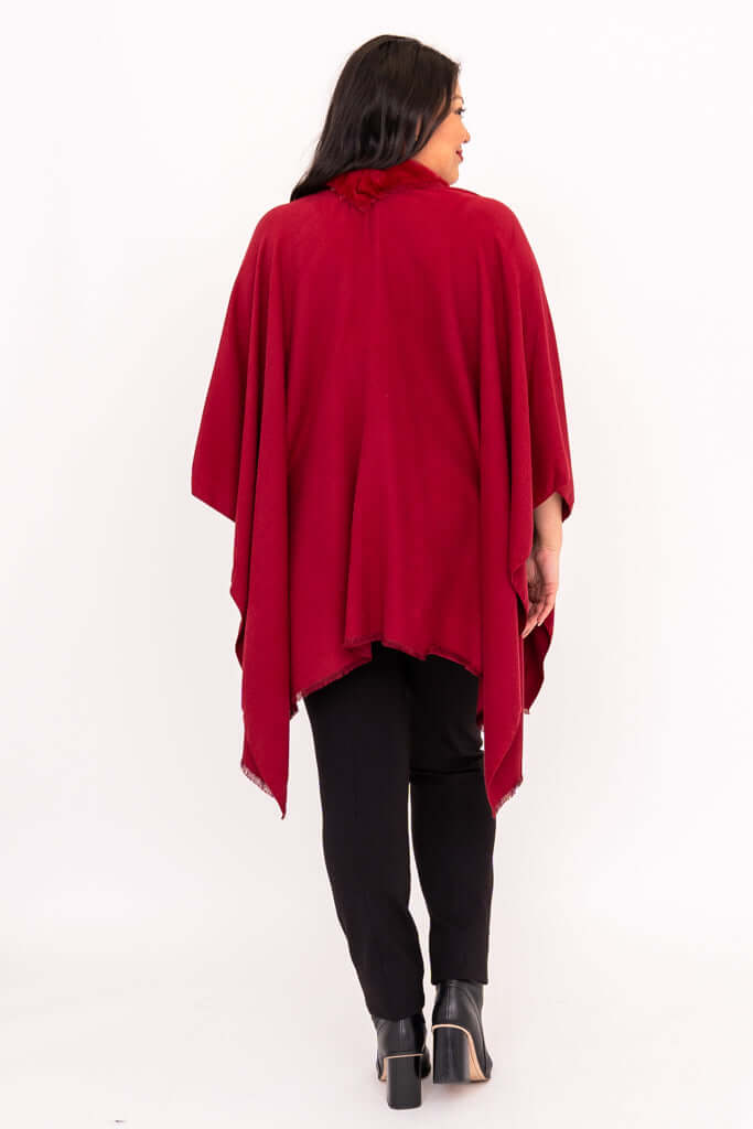 Back view of woman wearing a flowing red wrap with faux fur trim