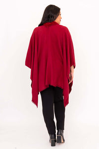 Back view of woman wearing a flowing red wrap with faux fur trim