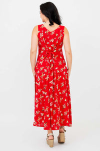 Back view of a woman wearing a red floral maxi dress with a tie-back detail
