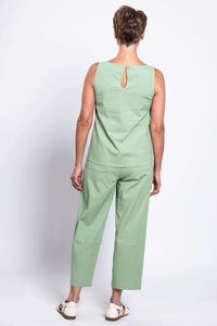 Back view of woman wearing sage green cropped pants and sleeveless top, showing pockets