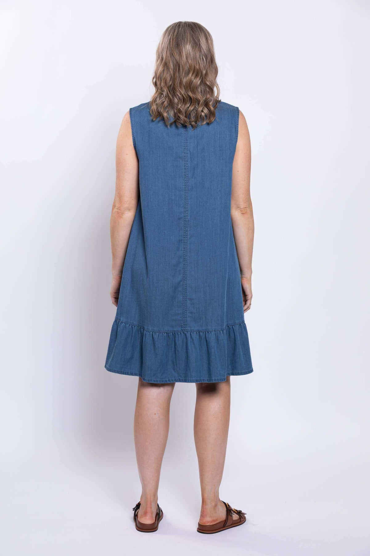 Rear view of sleeveless blue dress with ruffle hem and straight seam