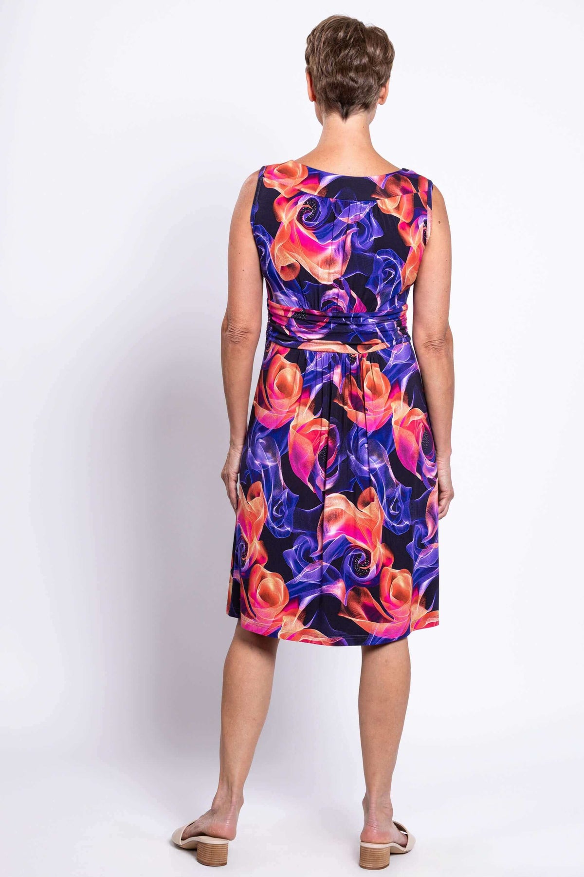 Back view of woman in sleeveless dress with colorful swirl print