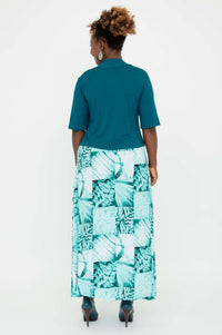 Back view of model showcasing the fit of the teal cropped bamboo jacket and long dress
