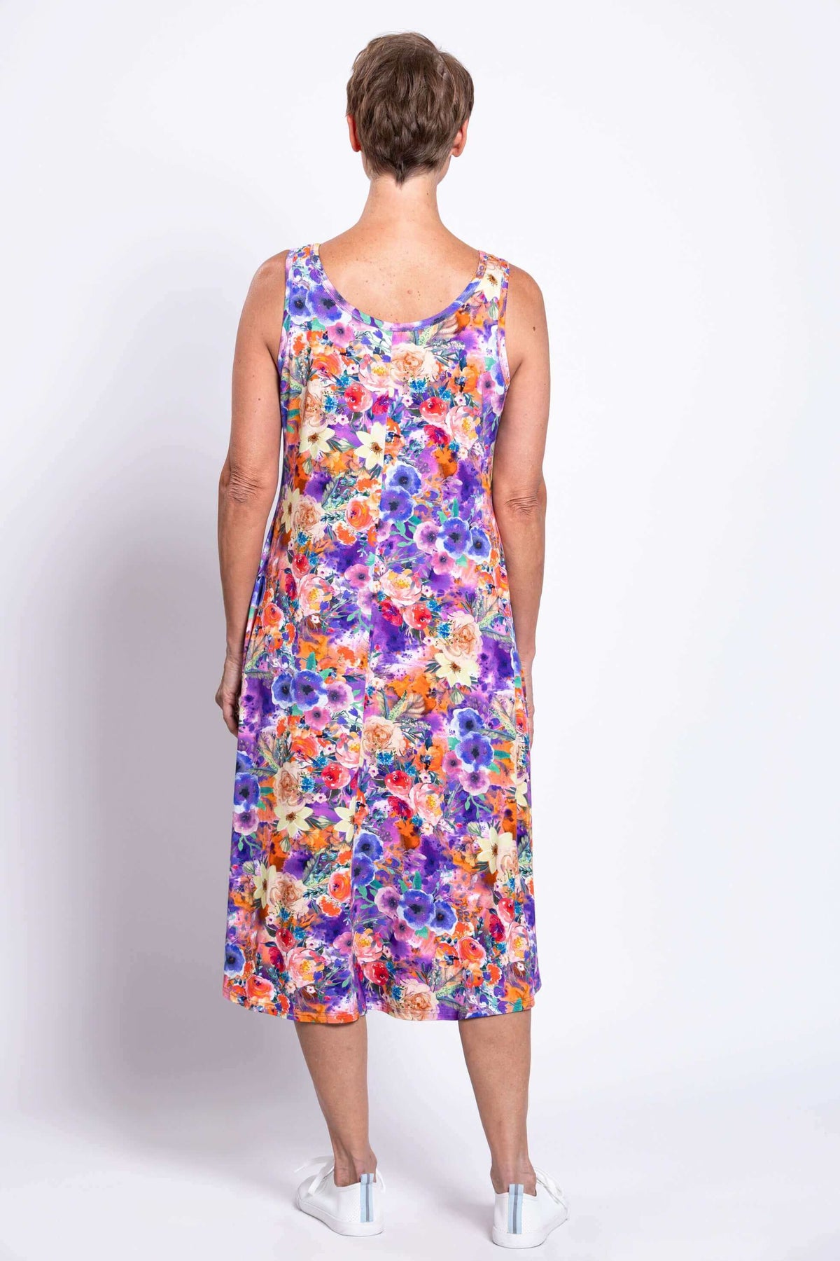 Back view of a woman wearing a colorful floral tank dress showing full coverage