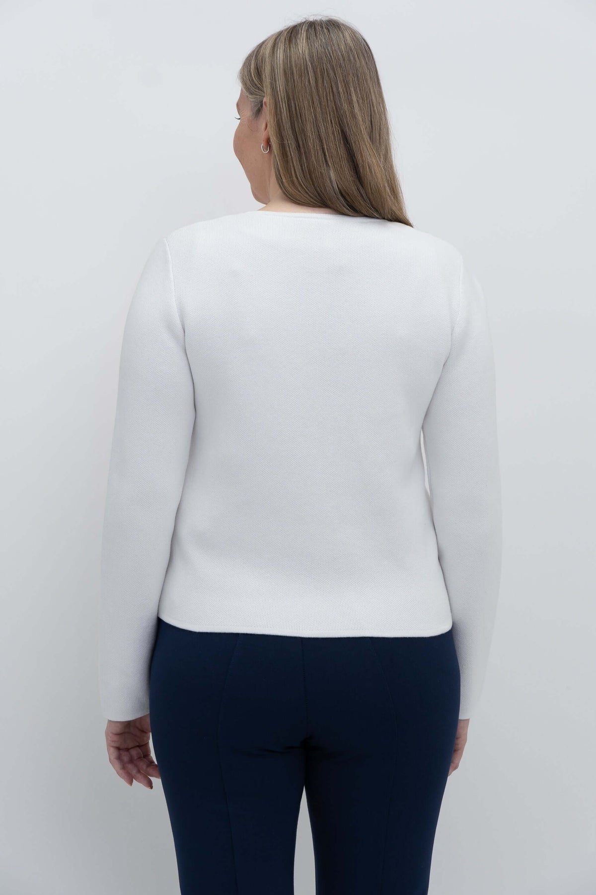 Back view of a woman wearing a white cardigan, showing the fit and length