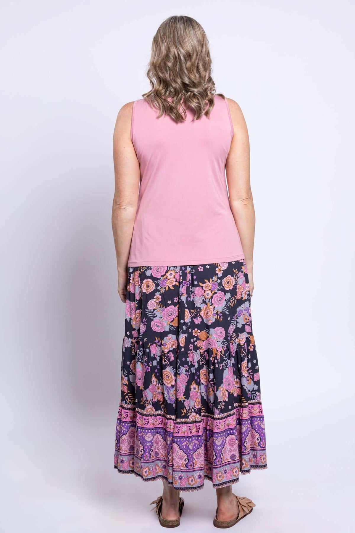 Back view of woman in Tibby floral skirt and pink tank top