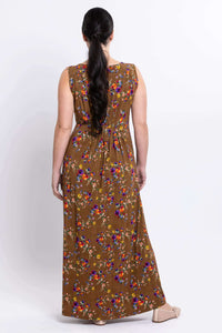 Back view of woman in a sleeveless brown floral maxi dress