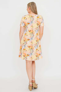 Back view of woman in pastel bamboo dress with colorful bird print