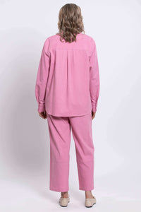 Back view of woman wearing pink relaxed fit shirt and matching pants