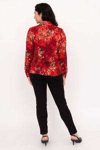 Back view of woman wearing a red floral blouse and black pants