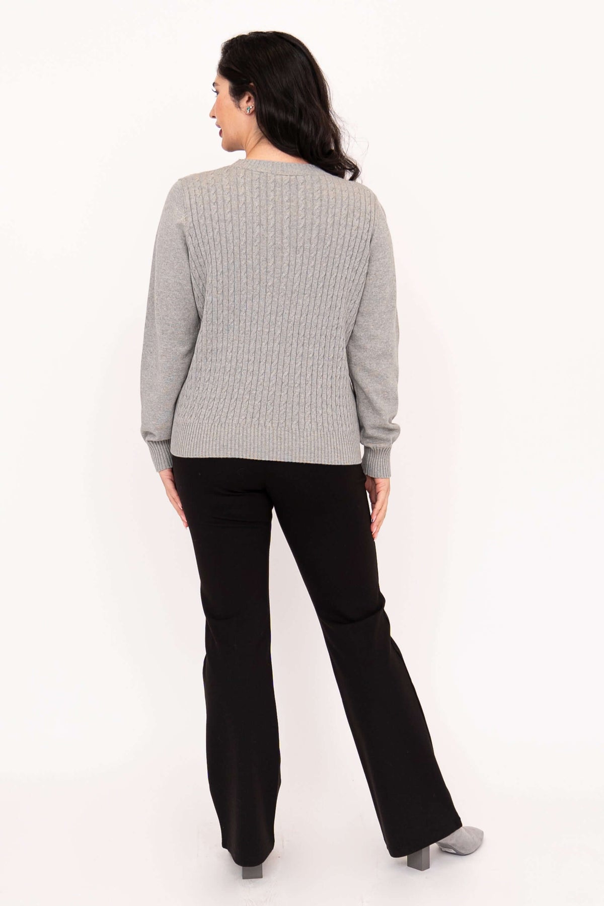 Back view of woman showing cable knit design on grey sweater