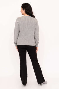 Back view of woman showing cable knit design on grey sweater