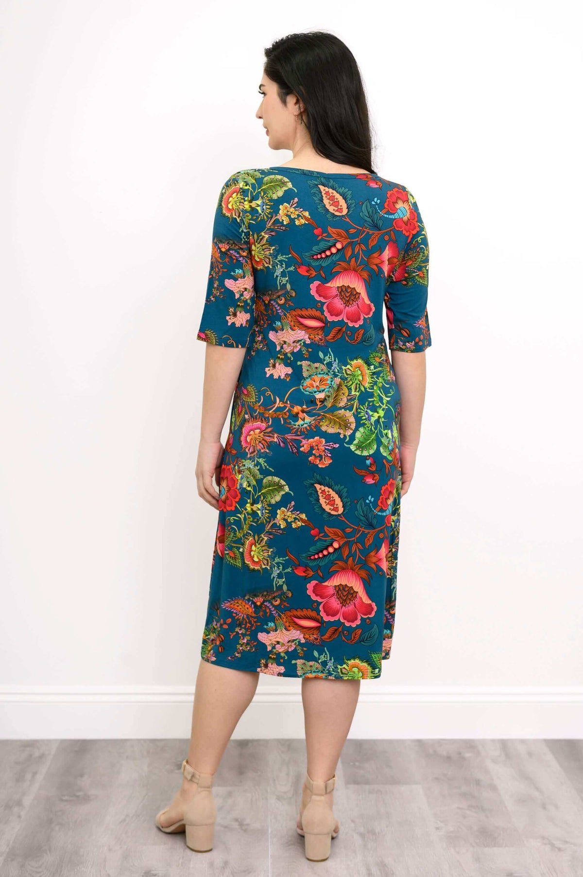 Back view of a woman modeling a knee-length bamboo dress with bright floral design