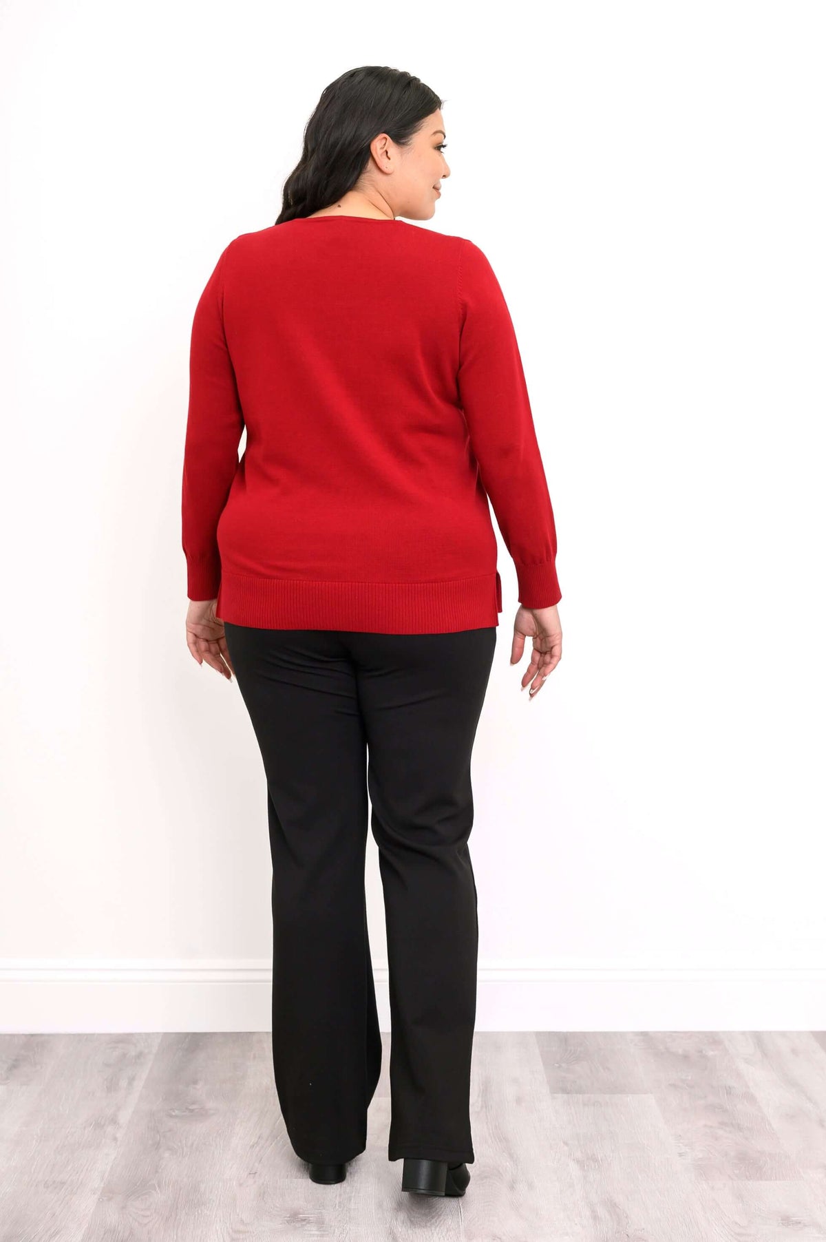 Back view of woman wearing red V-neck sweater with ribbed hem