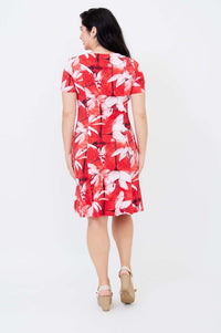 Back view of woman wearing a knee-length red bamboo dress with white floral print.