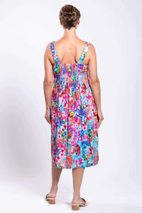 Back view of model in floral dress displaying shirred bodice and wide straps