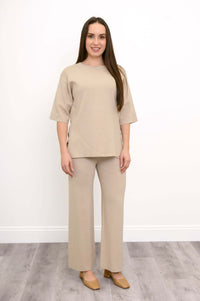Side view of a woman in the beige short sleeve Bailey Sweater