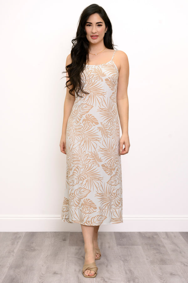 Front view of woman wearing a white and beige leaf-patterned dress against a white background