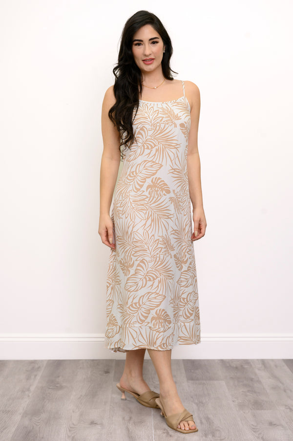 Front view of woman wearing a white and beige leaf-patterned dress against a white background