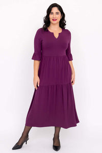 Woman wearing Bernadette dress, posing with one foot slightly forward to show skirt flow
