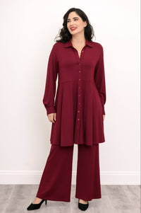 Front view of a woman wearing an open burgundy French terry button-down tunic shirt layered over a black top.
