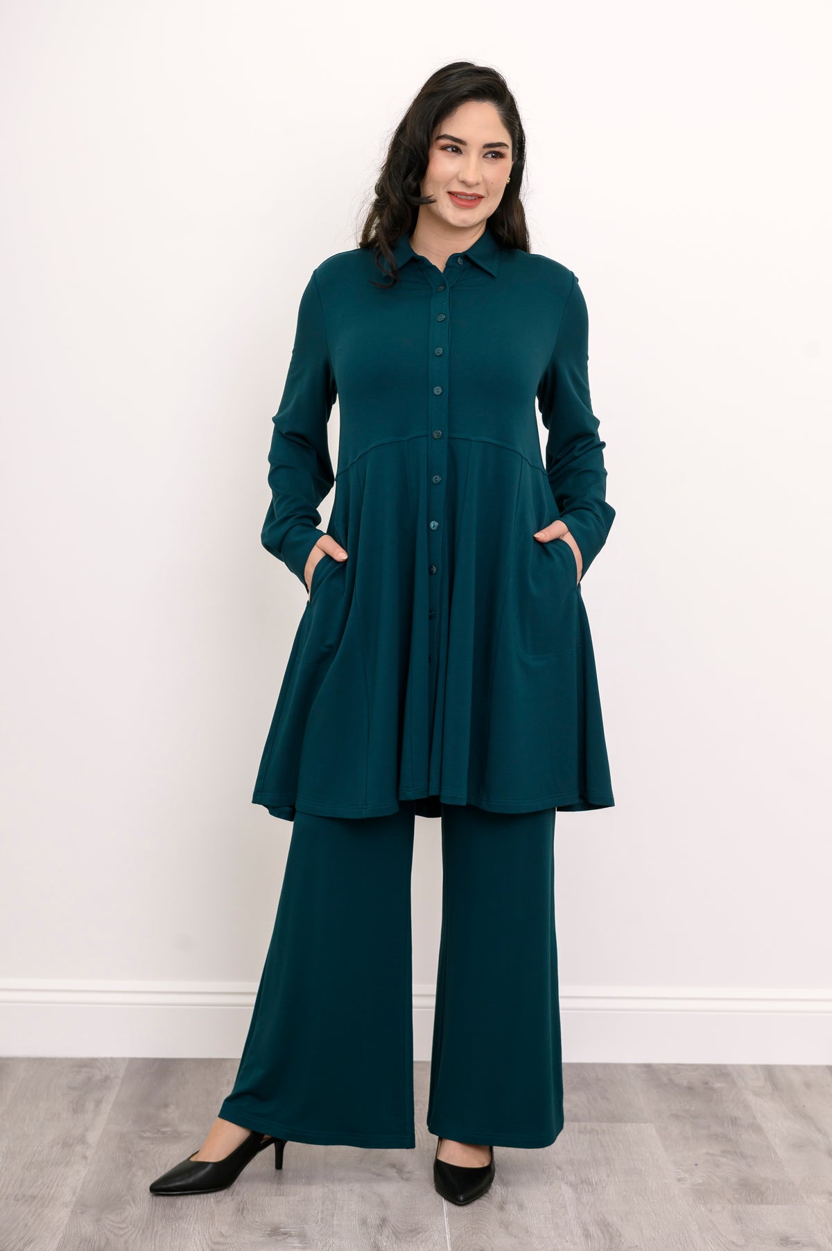 Wide shot of a loose-fit teal bamboo tunic shirt grounding the look with a strong vertical button line.