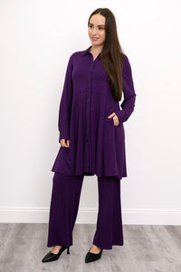 Wide studio shot of a loose-fit purple bamboo tunic with a structured skirted bottom and side pockets.