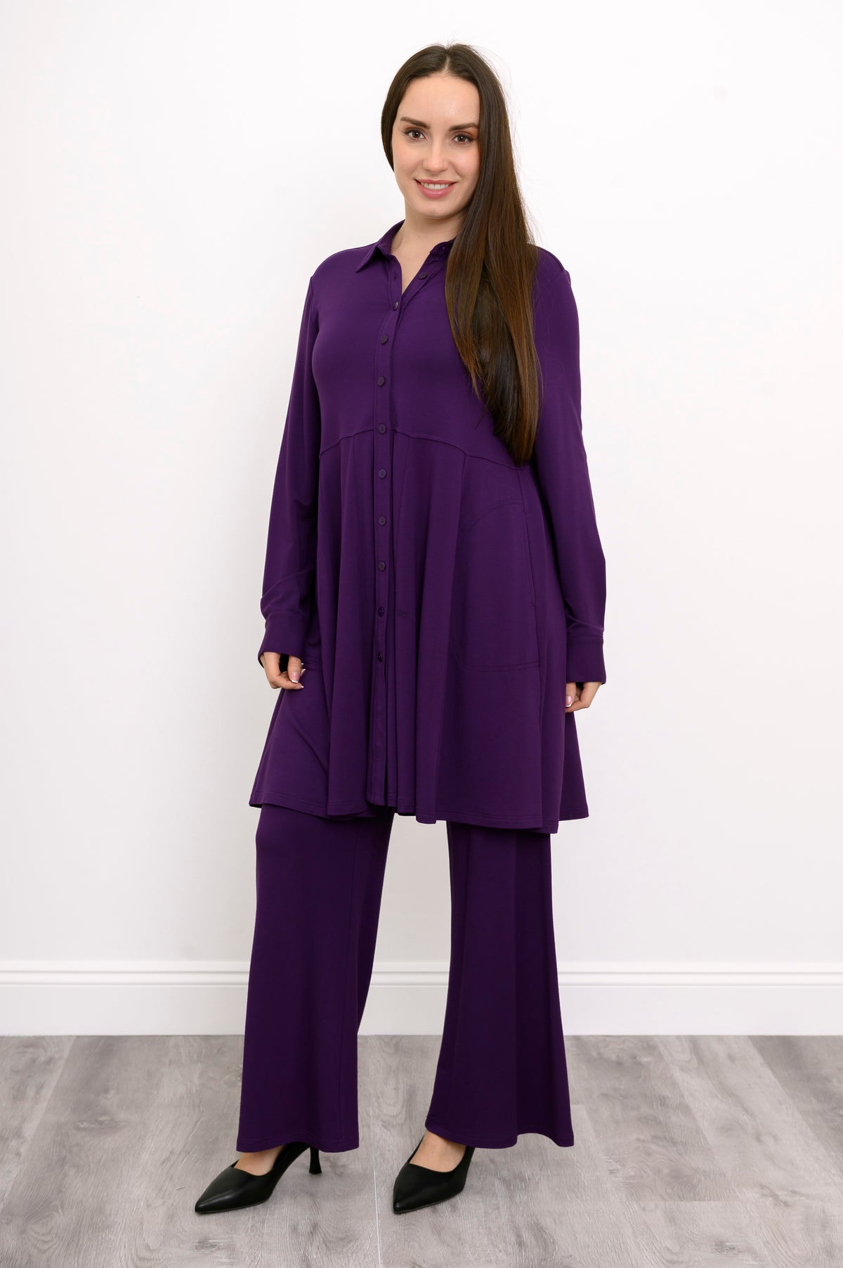 Wide studio shot of a relaxed-fit purple French terry tunic highlighting a strong vertical button placket.